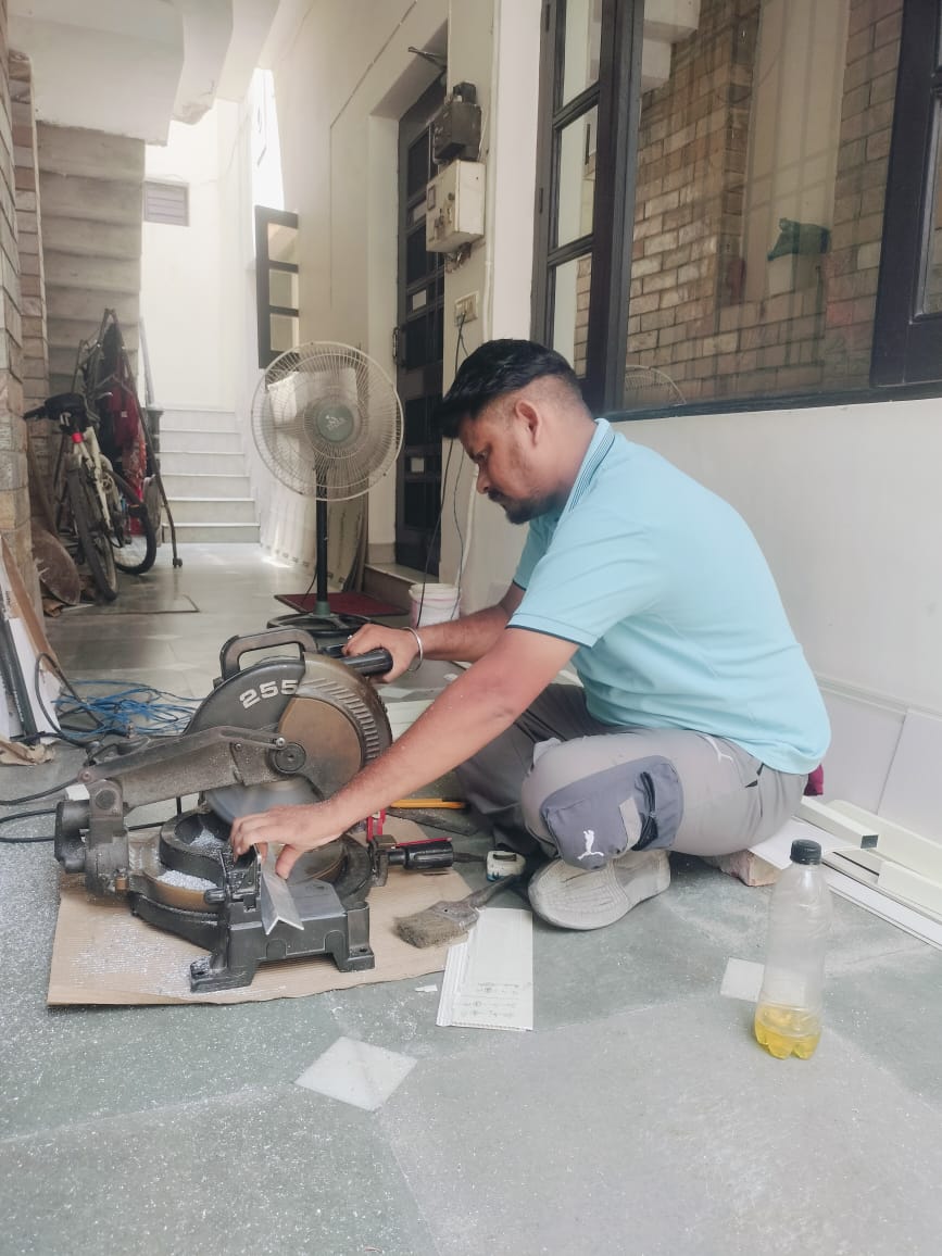 Fabricator making a precise 45-degree mitre cut on an aluminium section